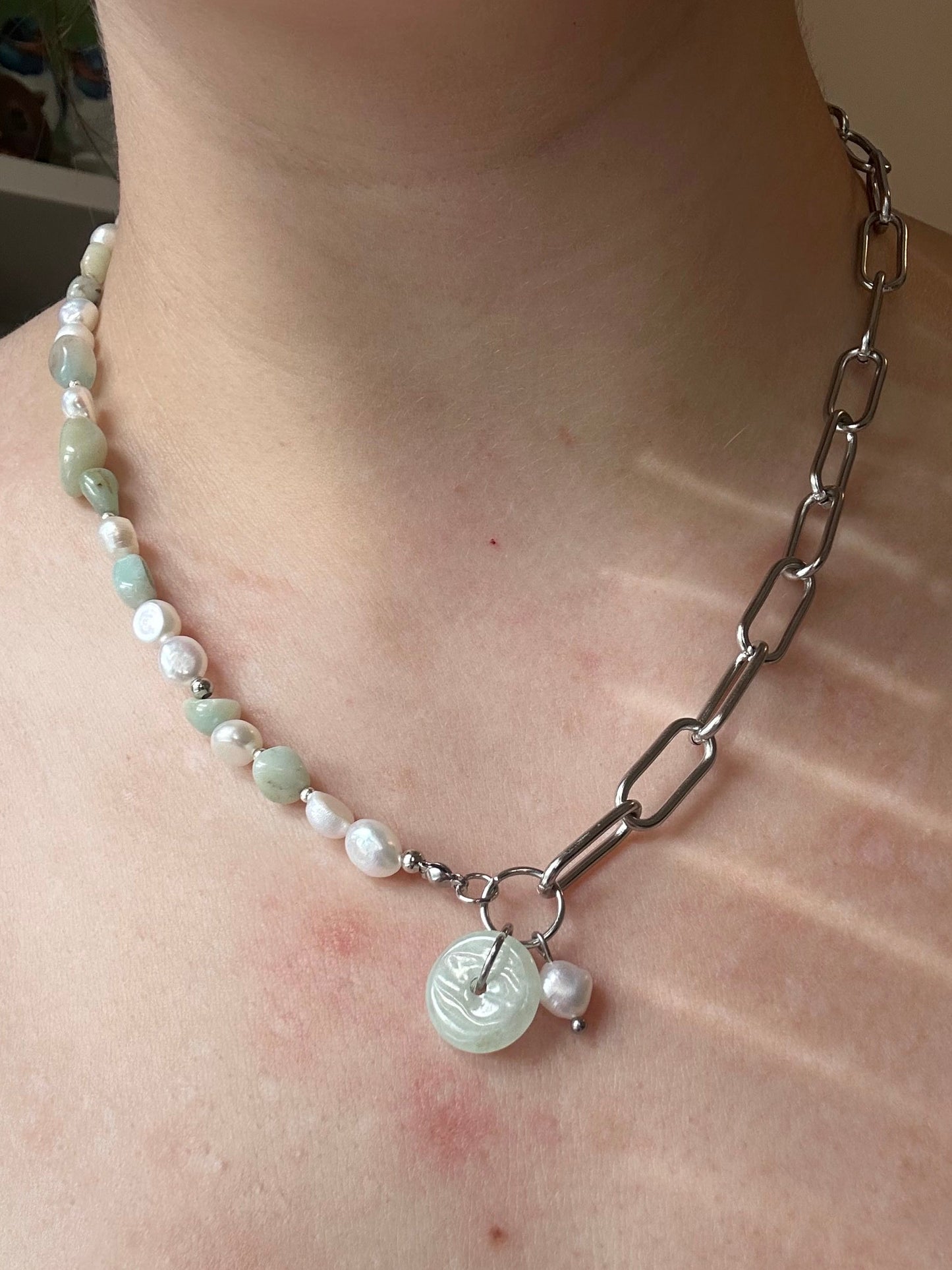 Pearl and Jade necklace worn around the neck, one half of the necklace is a paperclip chain