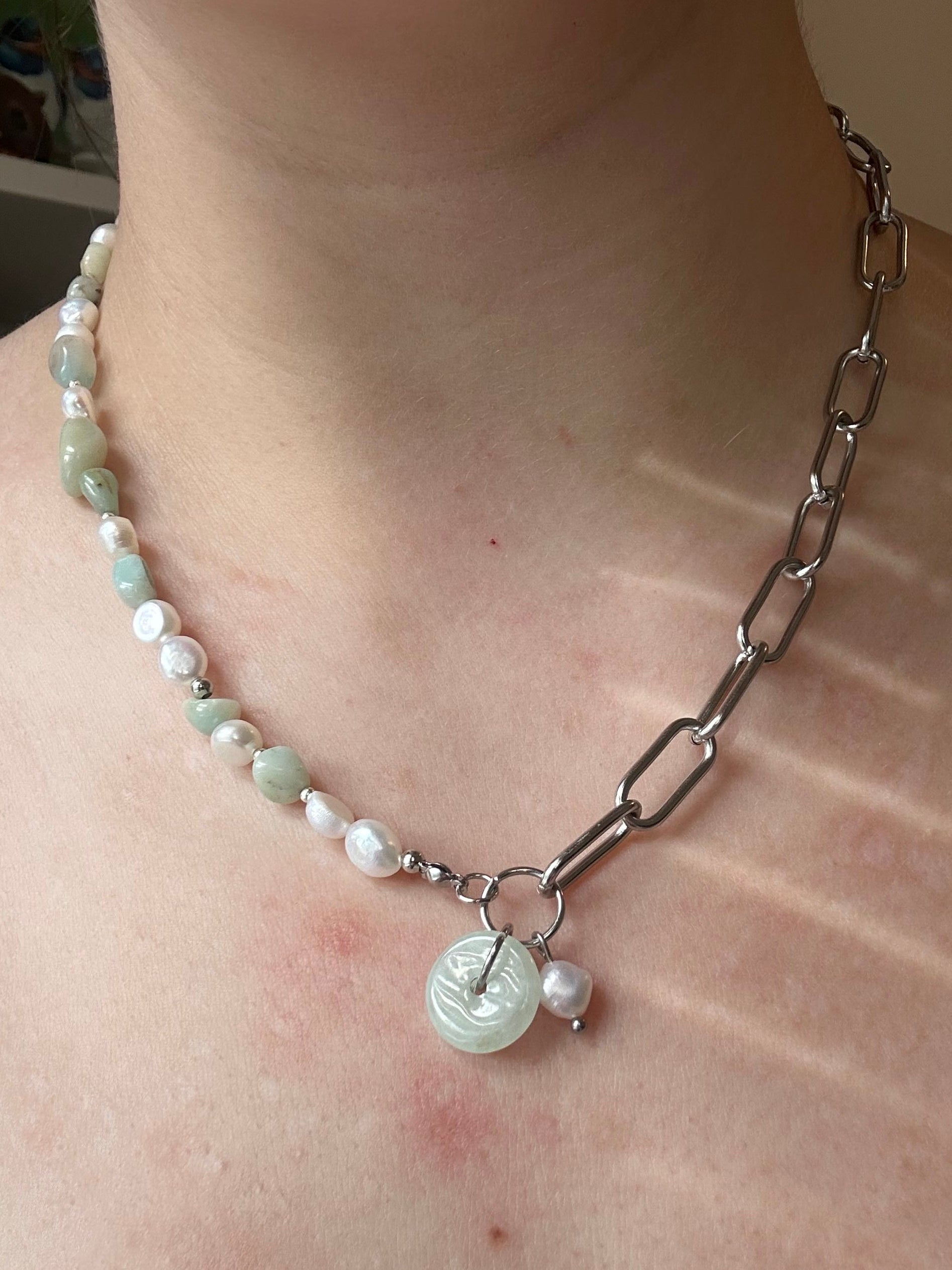 Pearl and Jade necklace worn around the neck, one half of the necklace is a paperclip chain